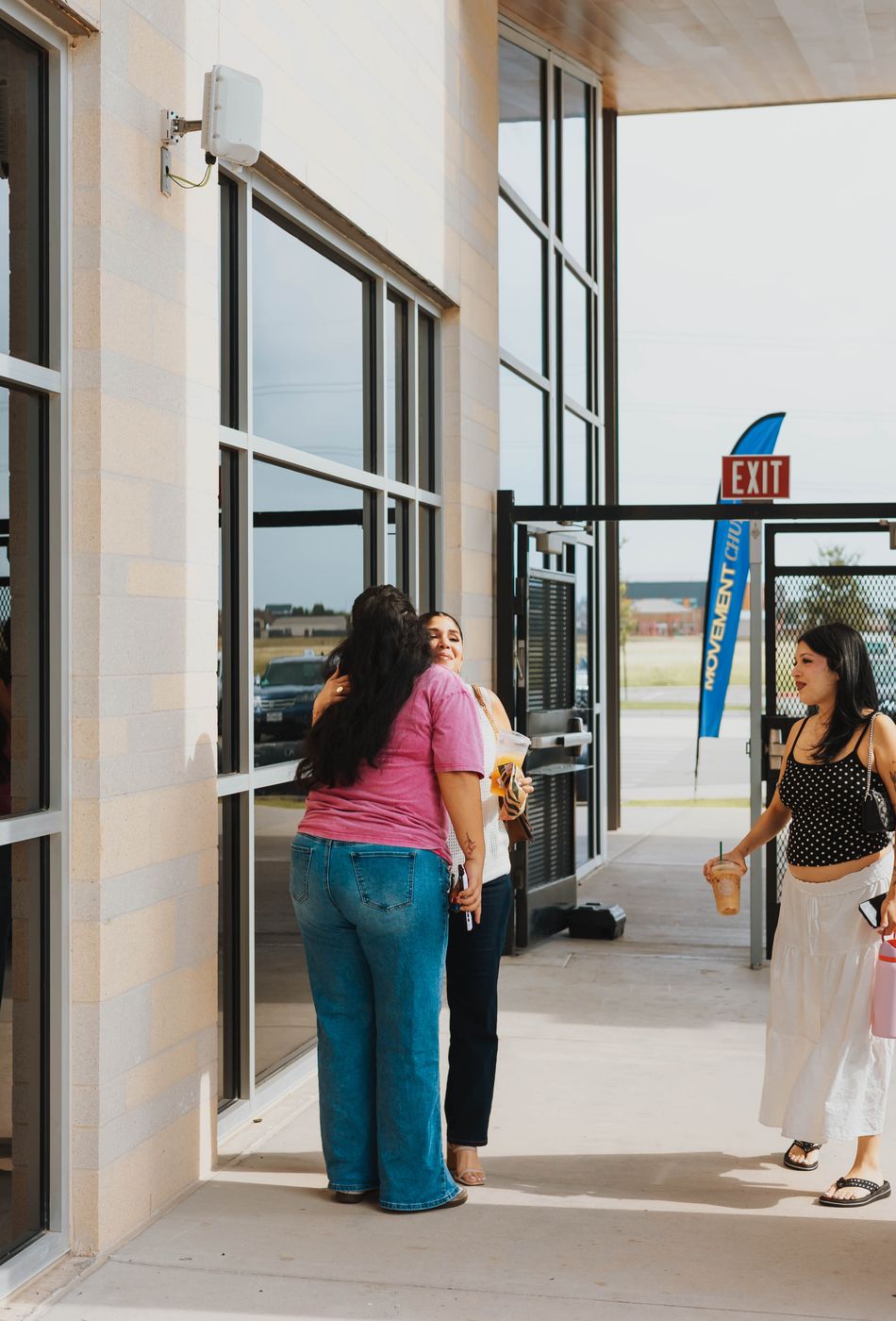 Women hugging and chatting together outside Movement Church