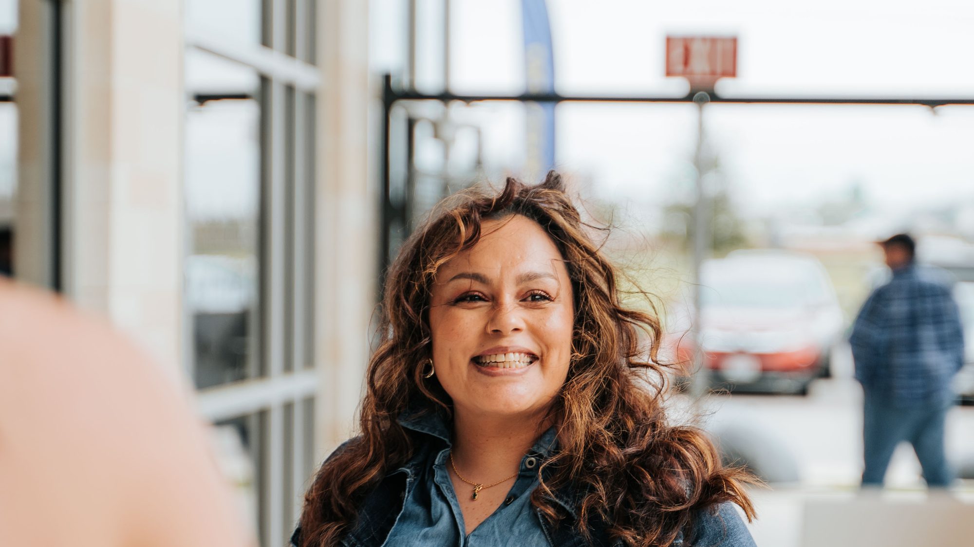 A smiling woman arriving at Movement Church on a Sunday morning