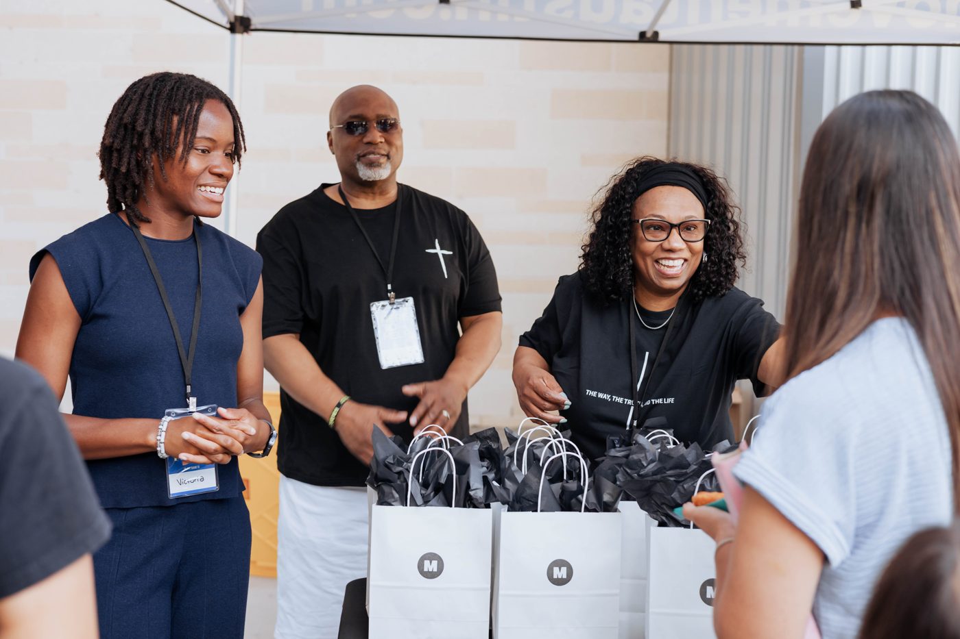 Dream Team volunteers handing out first-time guest bags