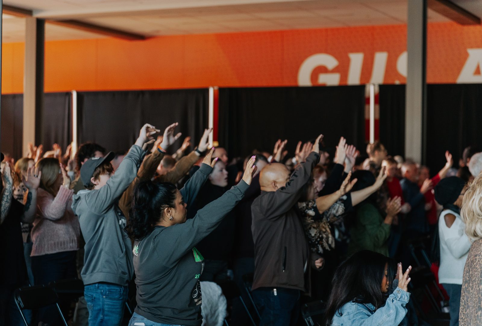 Congregation worshipping with hands raised at Movement Church