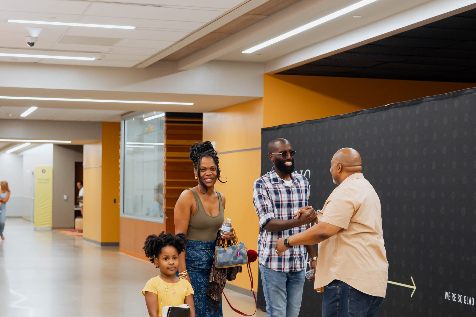 A family being warmly greeted as they arrive at Movement Church