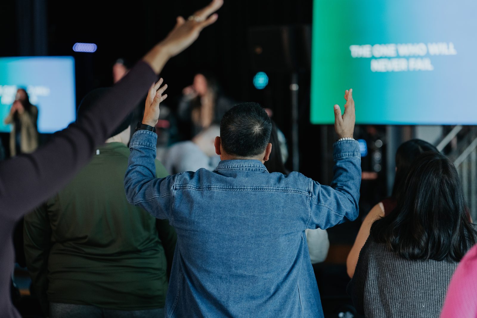 Hands raised in worship during a Movement Church service